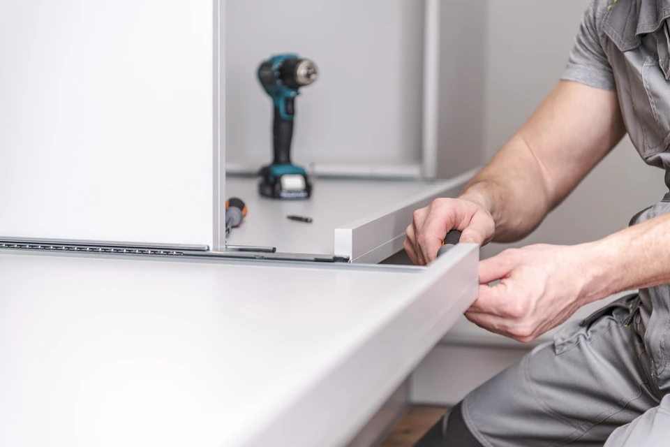 Artisan installant un plan de travail de cuisine dans un environnement domestique moderne