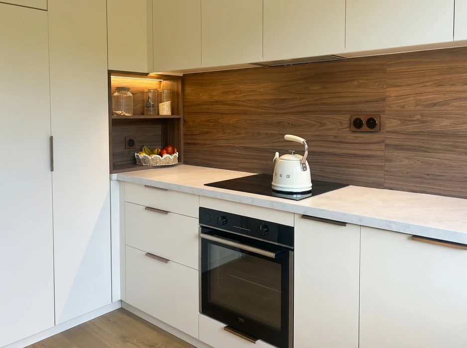 Photographie d'un petit espace réaménagé de manière optimale : une alcôve, un placard ou un renfoncement mural transformé par Into The Wood en rangement modulaire sur mesure. L'image doit montrer des étagères réglables, des tiroirs coulissants à sortie totale, et un système d'organisation vertical intelligent exploitant chaque centimètre disponible. Finitions en bois naturel ou laqué, quincaillerie Blum visible, éclairage LED discret intégré. L'aménagement doit démontrer clairement comment un espace contraint a été maximisé et fonctionnalisé. Photo prise légèrement en contre-plongée mettant en valeur l'ingéniosité de la conception et la précision de la fabrication artisanale. Environnement neutre, bien éclairé, valorisant le travail de menuiserie.