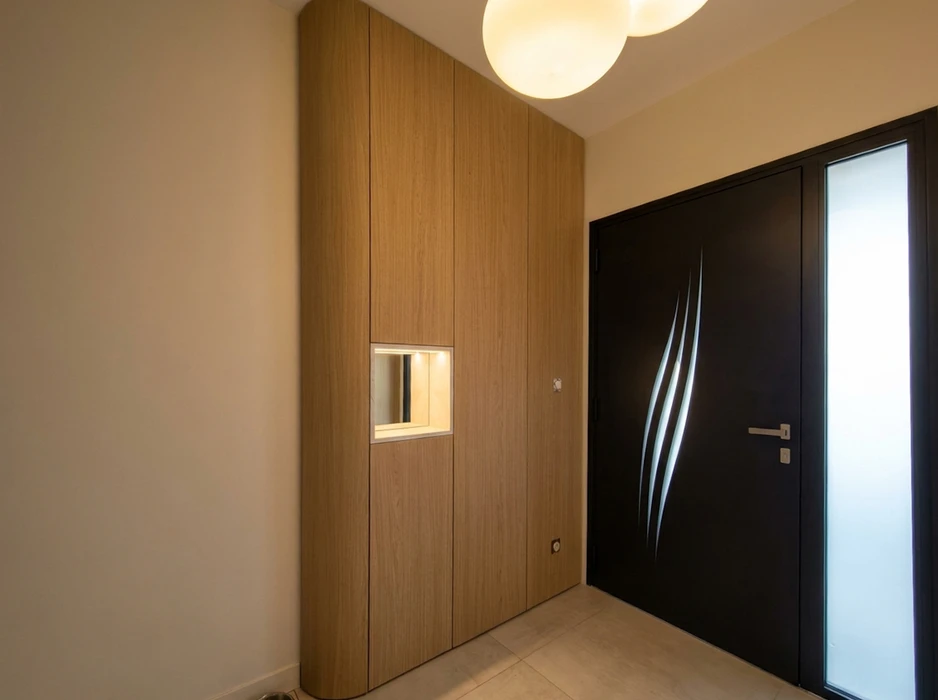Entrée moderne avec placard encastré en bois chêne naturel, intégrant un miroir encadré rétroéclairé LED