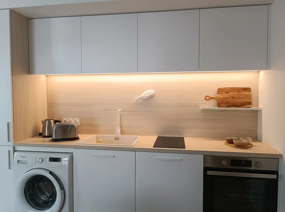 Cuisine moderne minimaliste avec façades de meubles gris mat, plan de travail stratifié décor bois clair