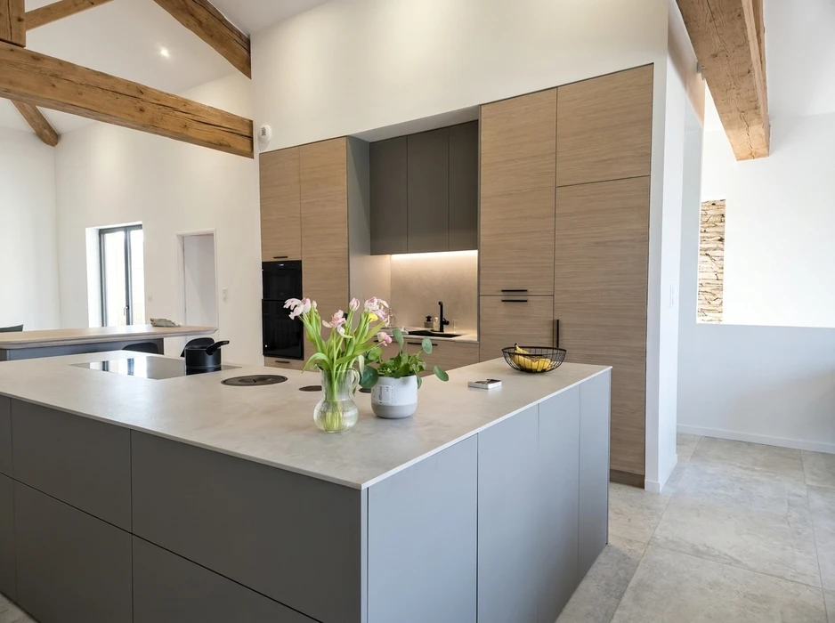 Cuisine moderne ouverte avec îlot central en pierre grise, plan de travail en quartz