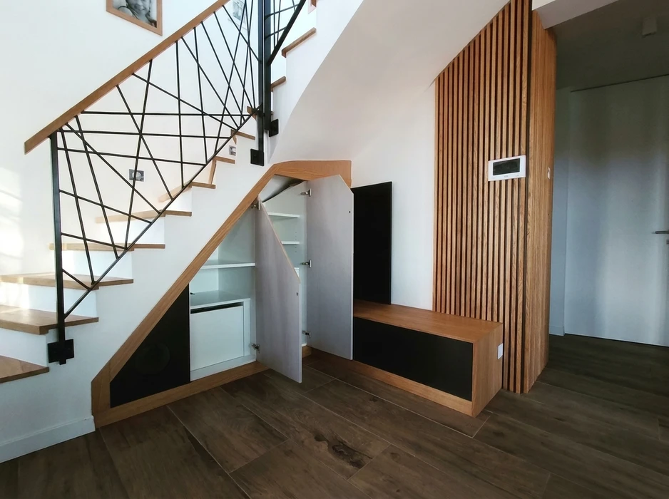 Escalier intérieur moderne avec garde-corps en métal noir géométrique et main courante en bois massif
