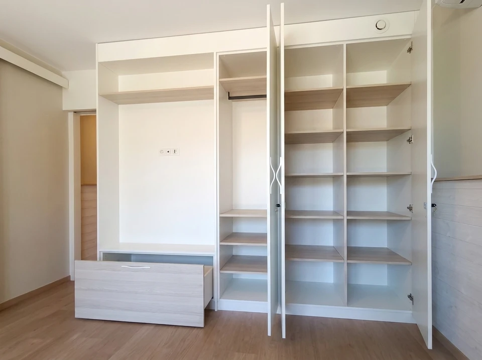 Cuisine moderne avec îlot central en bois massif, façades blanches laquées mat, plan de travail en quartz blanc