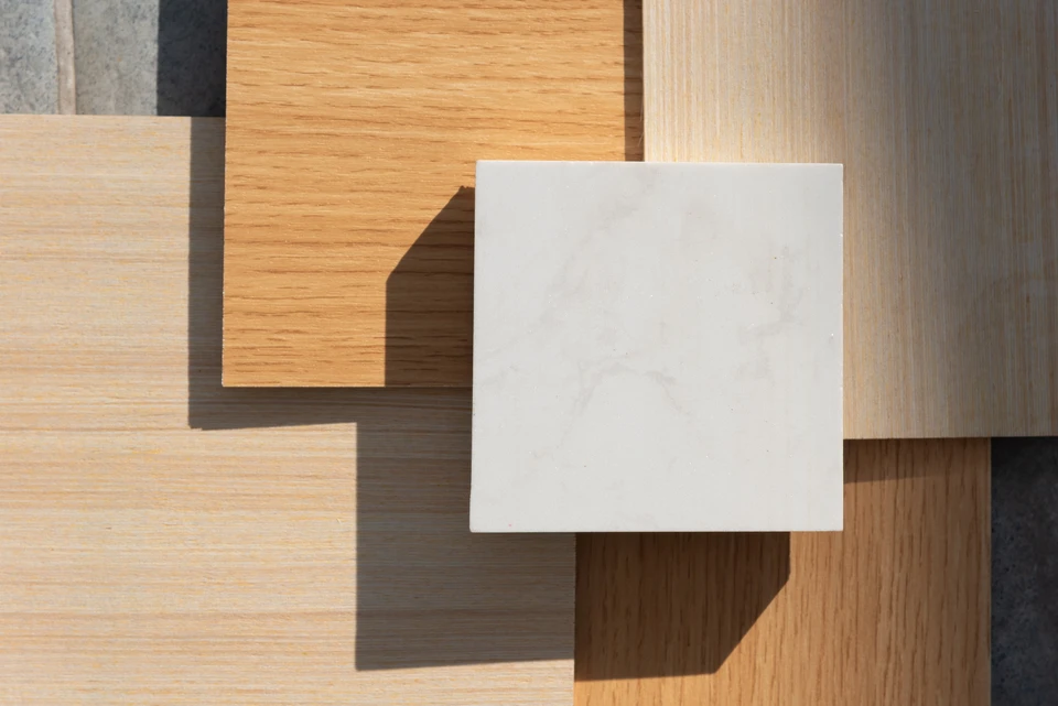 Une personne travaille sur des plans d'architecture à une table, tenant un stylo et utilisant une règle pour tracer des lignes précises